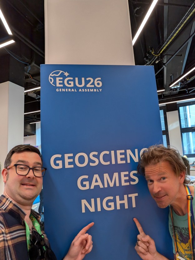 Myself and Rolf Hut posing in front of a sign for the Geoscience Games Night.