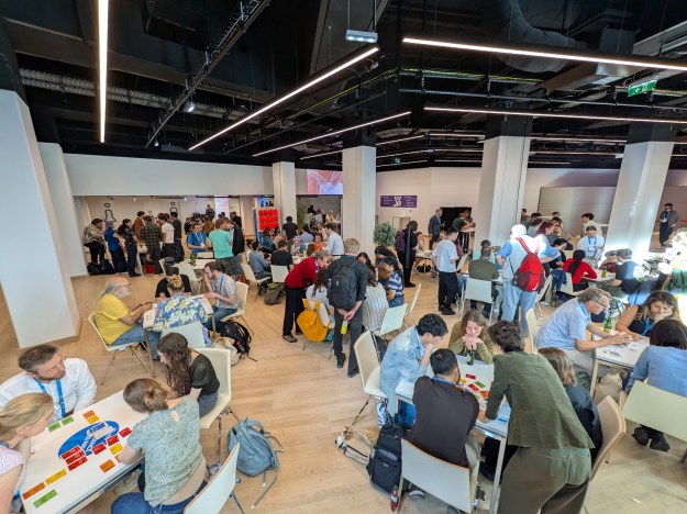 A busy room of people playing tabletop games.